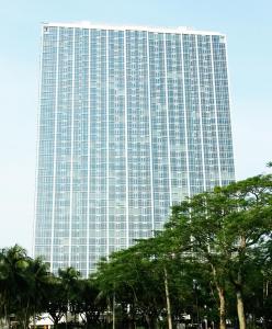 U Residence Tower2 Lippo Karawaci by supermal في Klapadua: مبنى طويل وبه أشجار أمامه