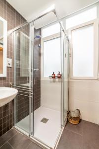 Apartamento Ronda Genil con parking gratuito في غرناطة: دش زجاجي في حمام مع حوض