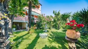 ogród z czerwonymi kwiatami i budynek w obiekcie Apartments and rooms with parking space Baska, Krk - 19424 w Bašce