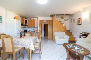 kuchnia i salon ze stołem i krzesłami w obiekcie Apartments with parking spaces Baska, Krk - 19675 w Bašce +7 zdjęć