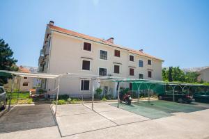 budynek z kortem tenisowym przed nim w obiekcie Apartments with a parking space Baska, Krk - 19443 w Bašce