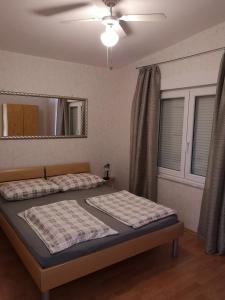 Un dormitorio con dos camas y un ventilador de techo. en Family-friendly apartments with swimming pool Jezera, Murter - 19541, en Tisno 6 fotos más