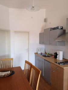 cocina con mesa de madera y encimera en Family-friendly apartments with swimming pool Jezera, Murter - 19541, en Tisno