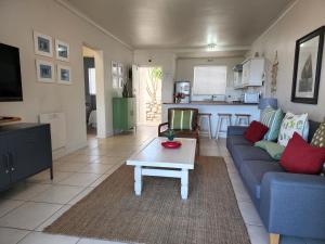 a living room with a blue couch and a table at The Potting Shed Self Catering in Hermanus