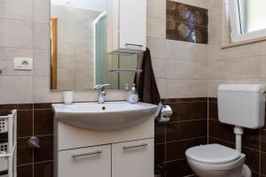 a bathroom with a sink and a toilet and a mirror at Apartments with parking space Dugi Rat, Omis - 19516 in Dugi Rat +26 photos