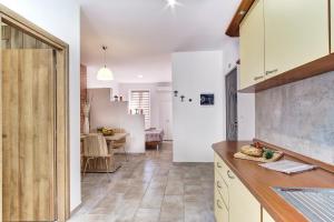 een keuken met witte kasten en een eetkamer bij Apartments with a parking space Mali Losinj, Losinj - 19618 in Mali Lošinj