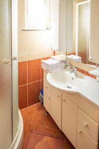 a bathroom with a white sink and a mirror at Family friendly house with a parking space Lokve, Gorski kotar - 19457 in Lokve