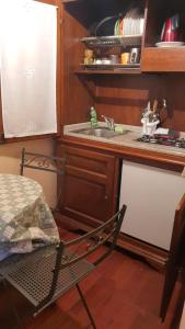 eine Küche mit einer Spüle und einem Stuhl neben einer Theke in der Unterkunft La Luna nel Borgo in Spello