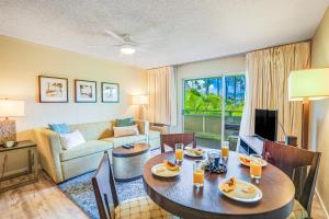 a living room with a table and chairs and a couch at Plantation Hale D10 in Kapaa