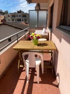 a wooden table and chairs on a balcony with flowers at Lugano Viganello in Lugano