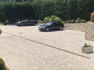 two cars parked in a parking lot next to a stone wall at Luxury Zen in Châteauneuf
