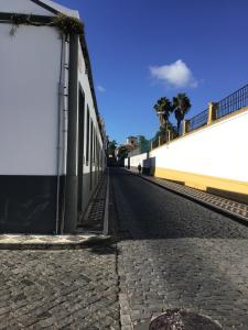 una strada vuota vicino a un muro bianco di Yellow Flat One Azores a Ponta Delgada