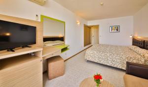 a hotel room with a bed and a flat screen tv at Hotel Nona in Albena