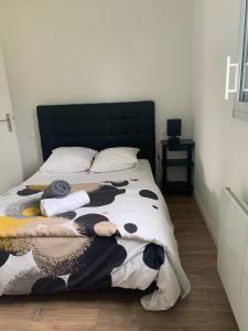 科當的住宿－Maison contemporaine à Caudan，床上有黑白牛毛毯