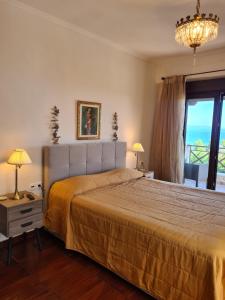 a bedroom with a large bed and a large window at Daphne Villas in Kriopigi
