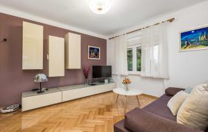 a living room with a couch and a tv at Vallelosca Garden in Opatija