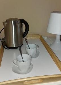 a tea kettle and two cups on a table at Mike's Rooms in Kobarid