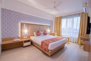 a hotel room with a large bed and a desk at Hotel Park Tree, Kolhapur in Kolhapur