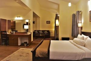 ein Hotelzimmer mit einem Bett und einem Wohnzimmer in der Unterkunft Nirvana Retreat in Kurseong