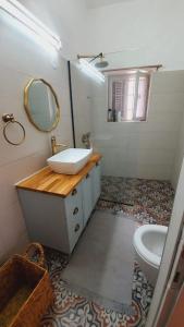 a bathroom with a sink and a mirror and a toilet at Lulia in Jerusalem