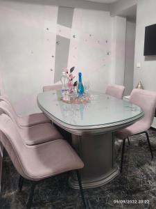 een glazen tafel met roze stoelen eromheen bij Amor, emoción y más, Auténtico apartamento céntrico climatizado,con wifi, cercano a la catedral y estaciones in Córdoba