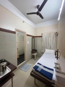 a bedroom with a bed and a ceiling fan at Golden Guest House in Bangalore