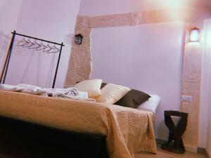 1 dormitorio con 1 cama y chimenea de piedra en LE ANTICHE MURA, en Vallecorsa