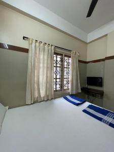 Un dormitorio con una cama grande y una ventana en Golden Guest House, en Bangalore