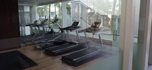 een fitnessruimte met verschillende loopbanden en een glazen wand bij A2 Pool Resort - SHA Plus in Phuket