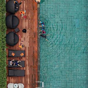 eine Aussicht auf Personen, die im Pool schwimmen in der Unterkunft HARRIS Hotel Batam Center in Batam Center