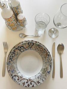 una mesa con un plato y utensilios. en Casa Eden Mesagne, en Mesagne