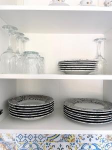 dos pilas de platos y vasos en un estante en Casa Eden Mesagne, en Mesagne