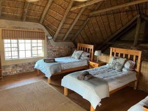 a bedroom with two beds in a attic at Intundla's Rest in Marloth Park