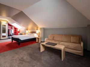 a bedroom with a bed and a couch in a room at ibis Montargis in Montargis