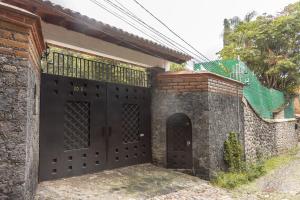 einen Eingang zu einem Haus mit einer schwarzen Tür in der Unterkunft CASA ANTARES in Tepoztlán