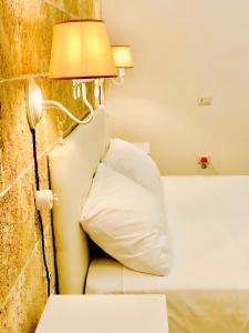 una camera da letto con un letto con una lampada accanto di Corte Gabellone - dimora storica a Nardò