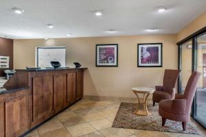 a lobby with a bar and two chairs and a table at Quality Inn Columbus-East in Columbus