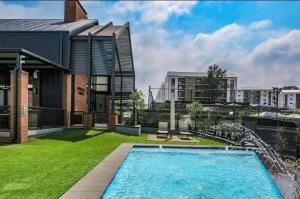a house with a swimming pool next to a building at Apartment in Boksburg in Witfield
