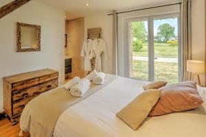 a large white bed in a room with a window at La Bergerie in Saint-Fargeau