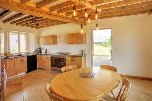 a kitchen with a wooden table and a dining room at La Bergerie in Saint-Fargeau