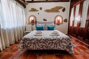 a bedroom with a large bed with blue pillows at Hotel Rural Finca La Herencia in Guadalcanal