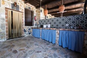 a kitchen with blue counter tops in a stone wall at Hotel Rural Finca La Herencia in Guadalcanal