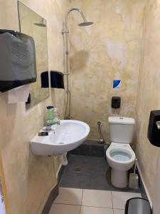 een badkamer met een wastafel en een toilet en een tv bij Hippie City Hostel in Chania