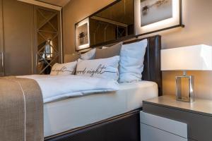 a bedroom with a large white bed and a table at Deluxe Apartment mit Tiefgarage in Nähe Messe-BMW-Porsche-DHL-Flughafen-Flugzeugwerk der Deutsche Aircraft in Leipzig