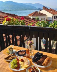 une table avec des assiettes de nourriture sur un balcon dans l'établissement Jovanovic Guest House, à Ohrid