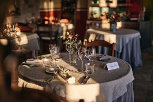 een tafel met wijnglazen en bloemen erop bij Casa Krasna Gourmet Boutique Hotel in Lokev
