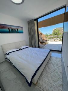 sypialnia z łóżkiem i dużym oknem w obiekcie lasuita-exclusive suites ceserea-luxury suite w mieście Cezarea