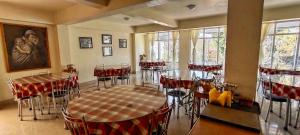 a restaurant with tables and chairs in a room at Shikher in Kalimpong