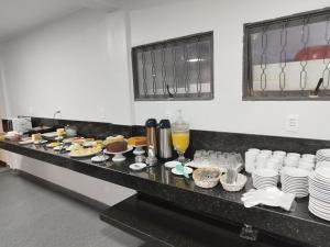 a buffet line with plates and cakes and desserts at Hotel Executivo formosa in Formosa