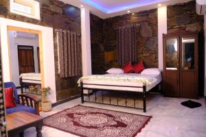 1 dormitorio con cama y pared de piedra en Emperor Palace A Heritage villa en Udaipur